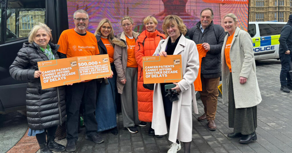 Pat Price poses with group holding signs for the #CatchUpWithCancer initiative